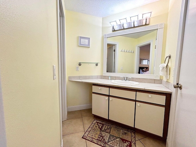 bathroom featuring tile patterned floors, vanity, and a textured ceiling