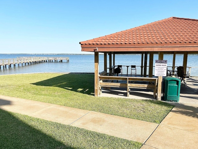 dock area with a water view and a yard