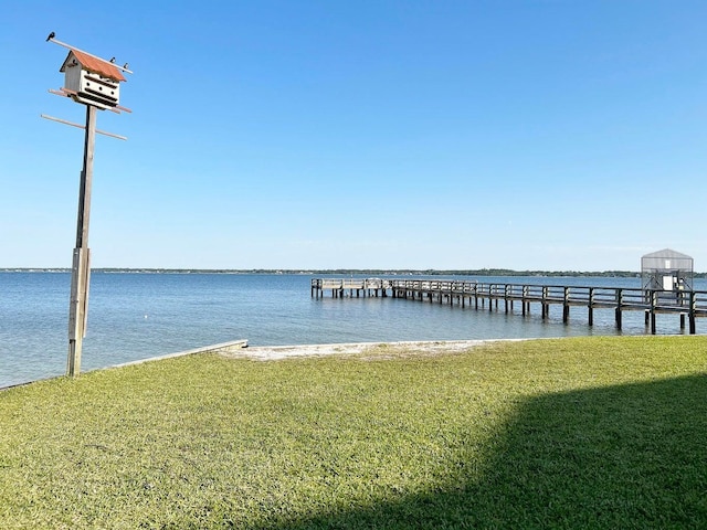 view of dock featuring a water view and a lawn