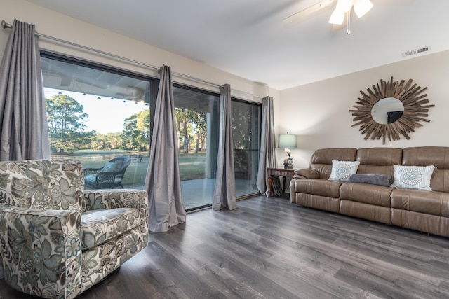 living room featuring ceiling fan and dark wood-type flooring