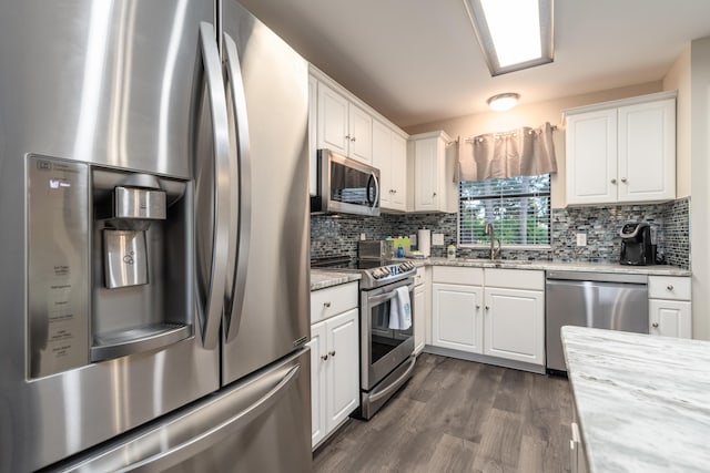 kitchen featuring decorative backsplash, appliances with stainless steel finishes, and white cabinetry