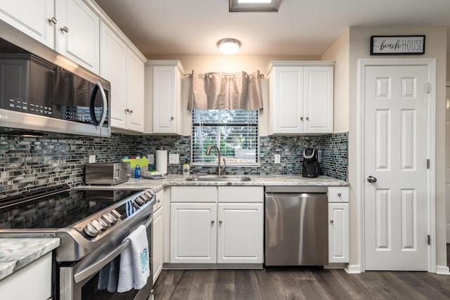 kitchen with light stone counters, sink, white cabinets, and appliances with stainless steel finishes