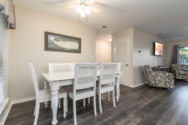 dining space with ceiling fan and dark wood-type flooring