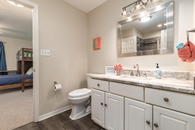 bathroom with hardwood / wood-style flooring, vanity, curtained shower, and toilet