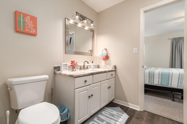 bathroom with hardwood / wood-style floors, vanity, and toilet