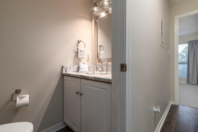 bathroom featuring hardwood / wood-style flooring, vanity, and toilet