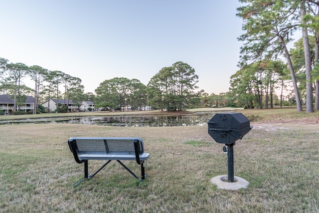 view of community with a lawn and a water view