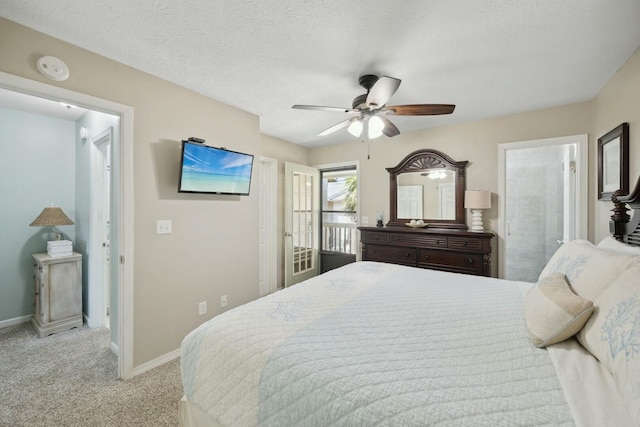 bedroom featuring a textured ceiling, ceiling fan, light carpet, and ensuite bath