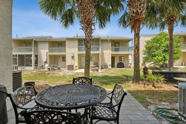 rear view of property with a yard and central AC