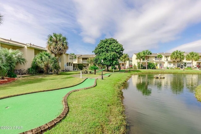 view of home's community featuring a lawn and a water view