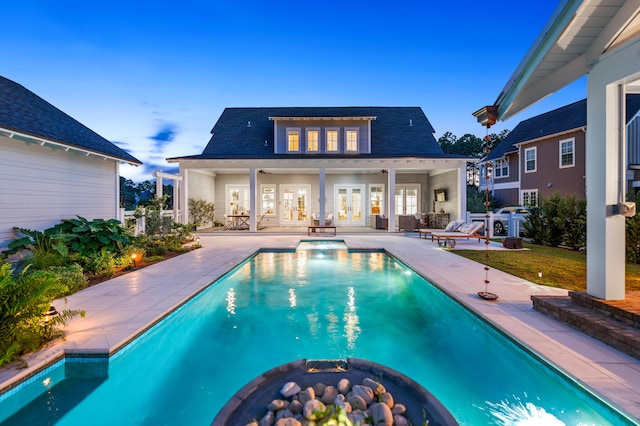 pool at dusk with a patio, an outbuilding, and an outdoor fire pit