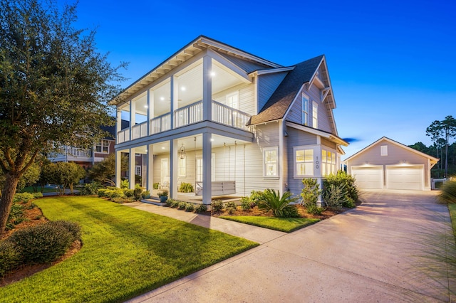 view of front of home featuring a lawn, a porch, a garage, an outdoor structure, and a balcony