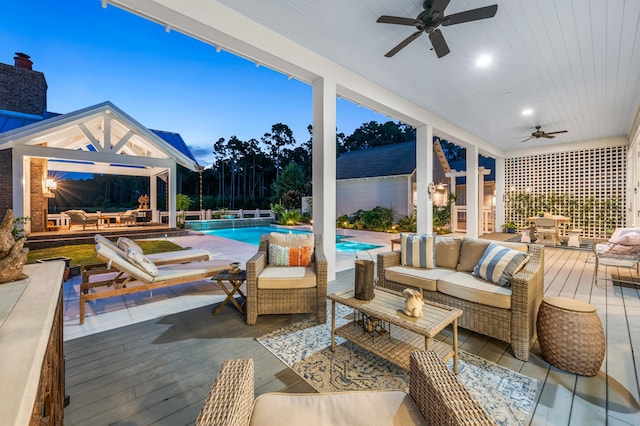 patio terrace at dusk featuring outdoor lounge area, a swimming pool side deck, and ceiling fan