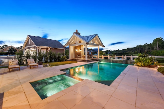 view of pool with an in ground hot tub, a fireplace, and a patio