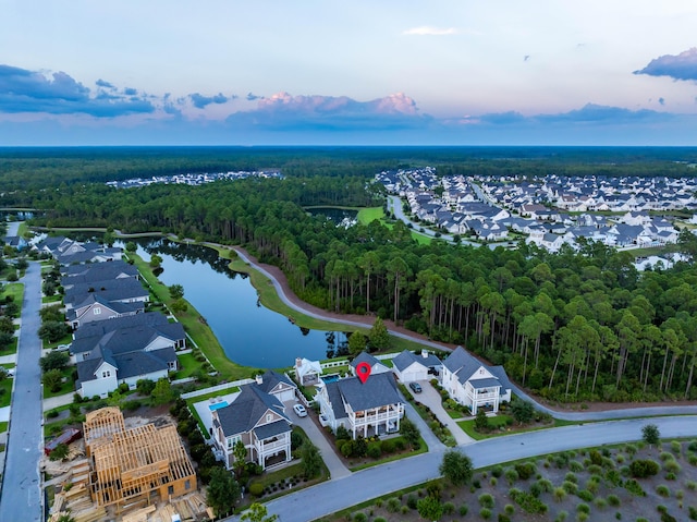 aerial view at dusk featuring a water view