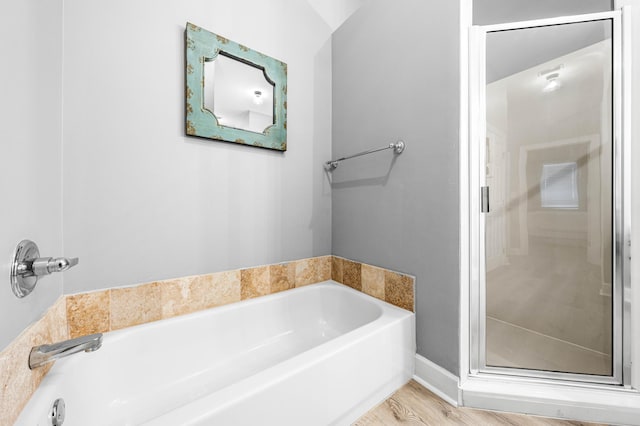 bathroom featuring wood-type flooring, separate shower and tub, and lofted ceiling