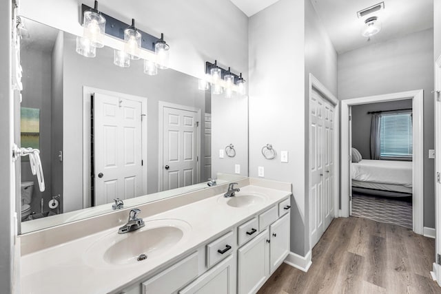 bathroom featuring vanity, hardwood / wood-style flooring, and toilet