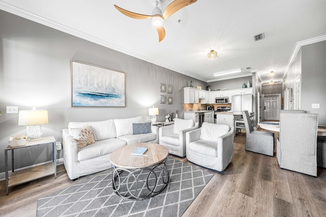 living room featuring ceiling fan, dark hardwood / wood-style floors, and ornamental molding