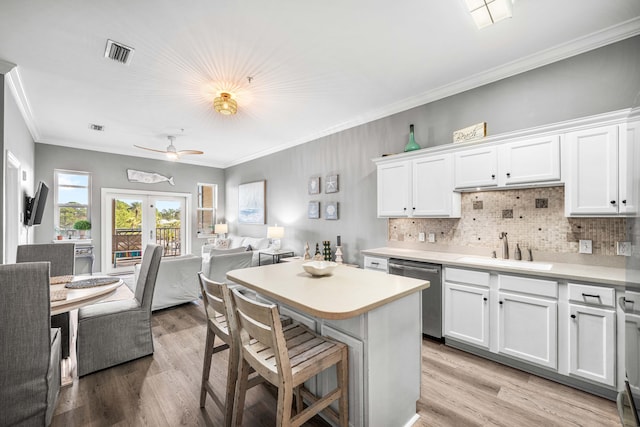 kitchen with backsplash, french doors, white cabinets, and stainless steel dishwasher