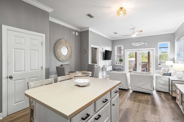 kitchen with ceiling fan, a center island, french doors, hardwood / wood-style floors, and white cabinets