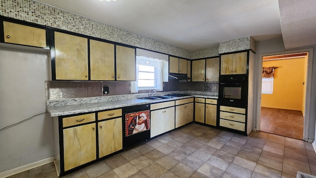 kitchen featuring black appliances, sink, tile patterned floors, and a textured ceiling