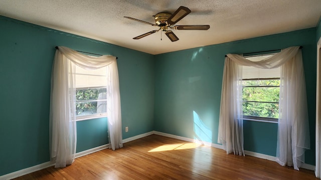 spare room featuring a textured ceiling, light hardwood / wood-style flooring, and ceiling fan