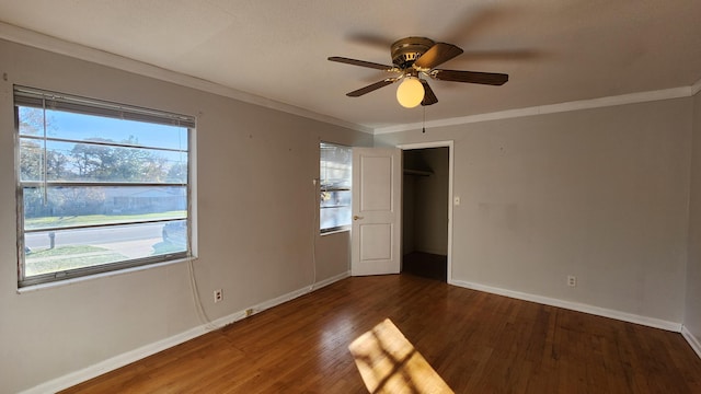 empty room with ceiling fan, dark hardwood / wood-style flooring, and ornamental molding