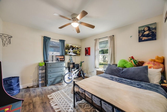 bedroom with a ceiling fan, baseboards, and wood finished floors