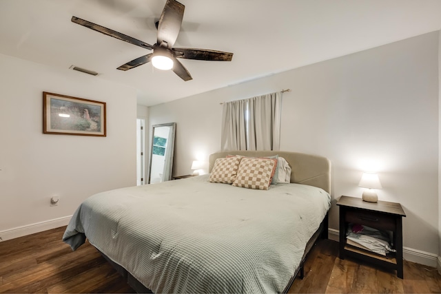 bedroom with dark wood-style floors, visible vents, baseboards, and a ceiling fan