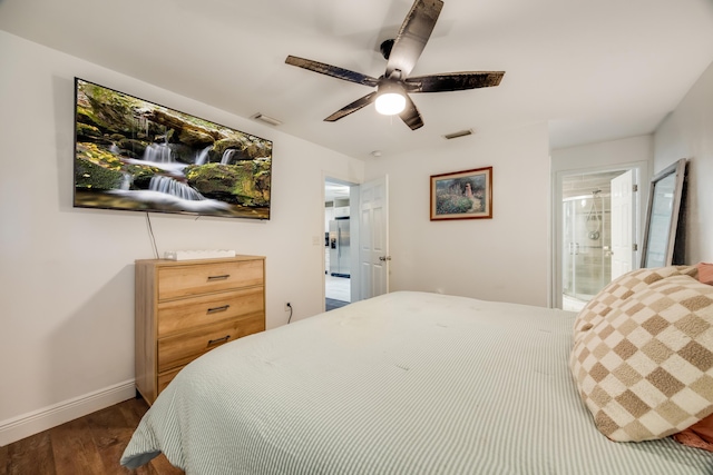 bedroom with ensuite bath, dark wood finished floors, visible vents, and baseboards