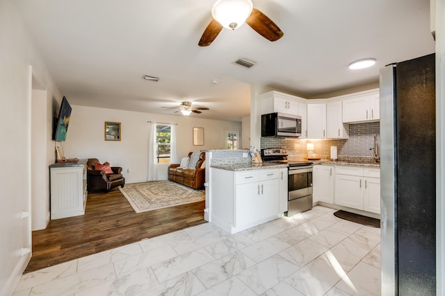 kitchen featuring marble finish floor, visible vents, appliances with stainless steel finishes, open floor plan, and white cabinets