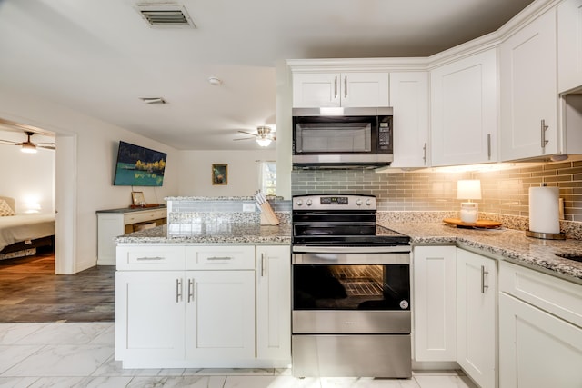 kitchen featuring appliances with stainless steel finishes, white cabinets, and visible vents