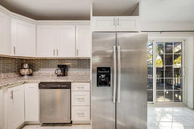 kitchen with light stone counters, stainless steel appliances, white cabinets, marble finish floor, and decorative backsplash