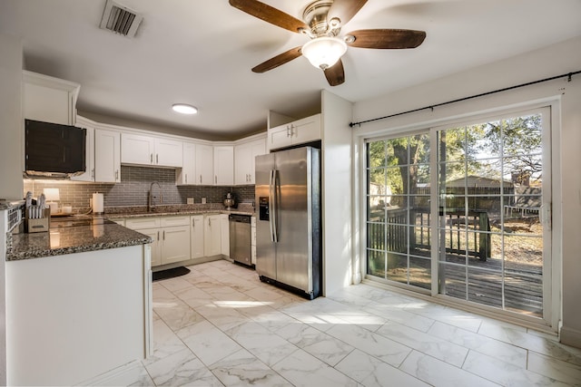 kitchen featuring marble finish floor, stainless steel appliances, visible vents, white cabinets, and dark stone countertops