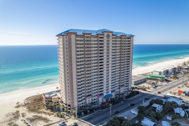 birds eye view of property with a water view and a beach view