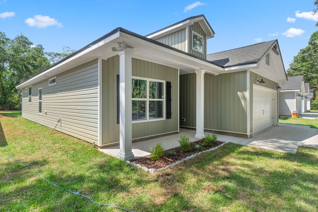 view of property exterior with a porch, a yard, and a garage