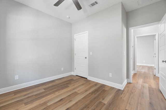 empty room with ceiling fan and hardwood / wood-style flooring