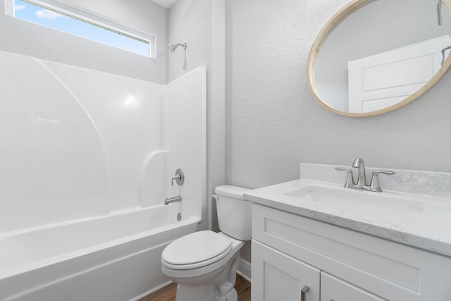 full bathroom with washtub / shower combination, vanity, hardwood / wood-style flooring, and toilet