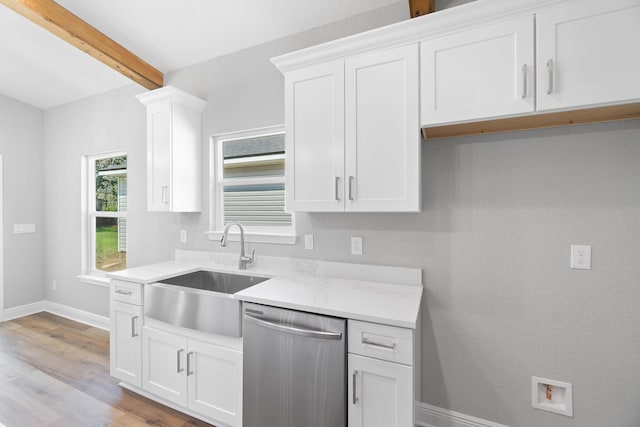 kitchen featuring stainless steel dishwasher, white cabinets, and beamed ceiling