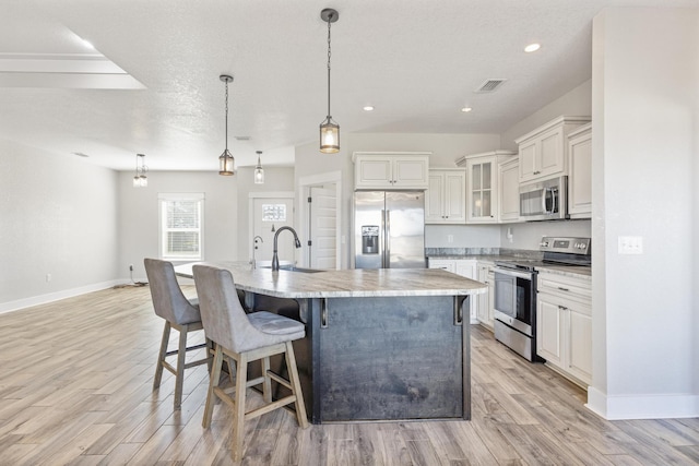 kitchen featuring a large island, sink, stainless steel appliances, and hanging light fixtures