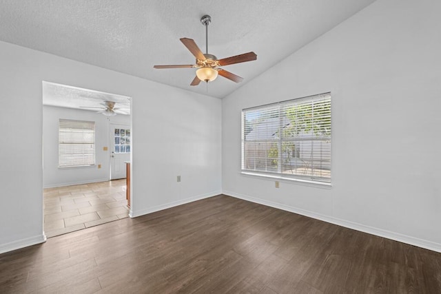 unfurnished room with ceiling fan, a healthy amount of sunlight, lofted ceiling, and dark wood-type flooring