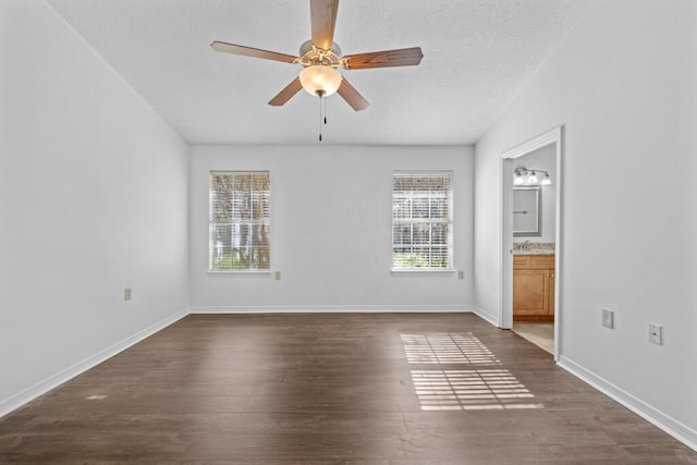 empty room with ceiling fan and dark wood-type flooring