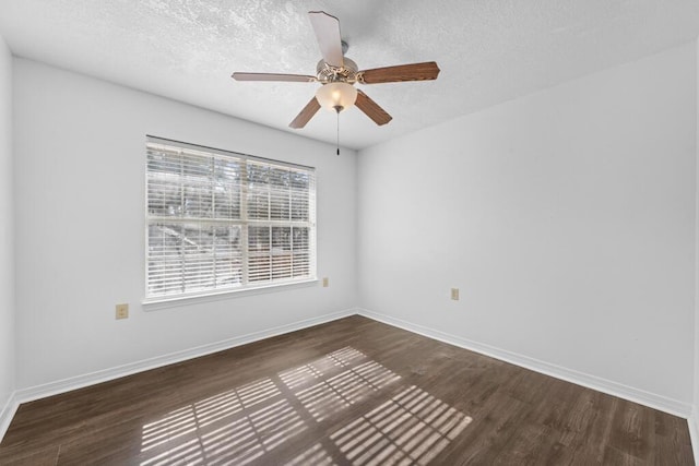 empty room featuring ceiling fan, dark wood-type flooring, and a textured ceiling