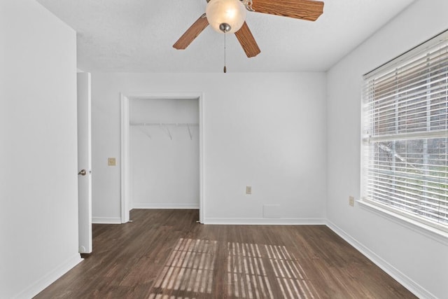 unfurnished bedroom with ceiling fan, dark wood-type flooring, and a closet