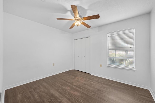 spare room featuring ceiling fan and dark wood-type flooring