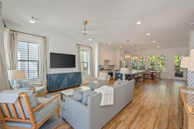 living room with ceiling fan and light wood-type flooring