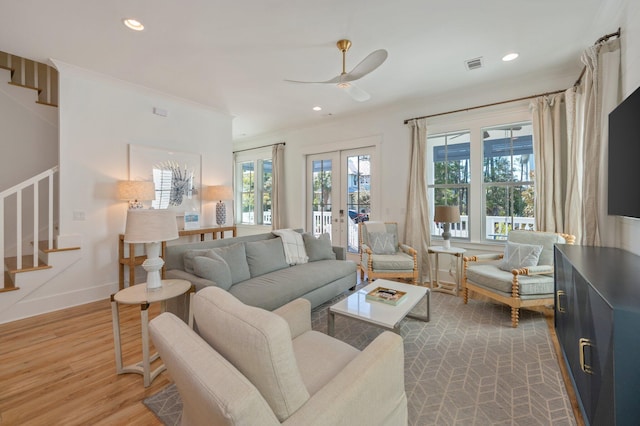 living room featuring wood-type flooring, french doors, ceiling fan, and ornamental molding