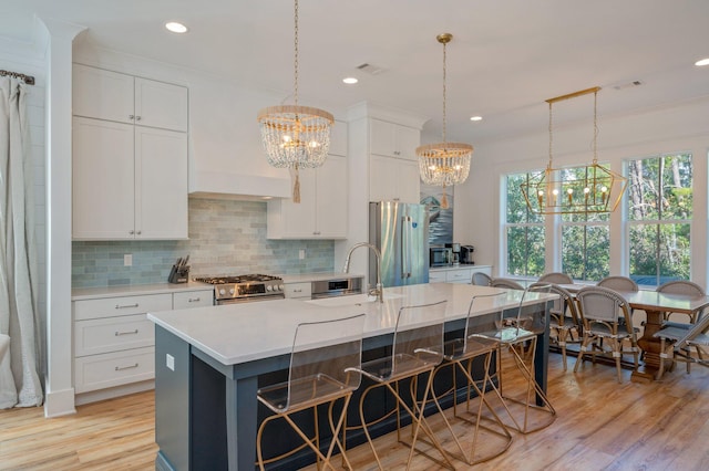 kitchen featuring sink, white cabinetry, a large island with sink, and appliances with stainless steel finishes