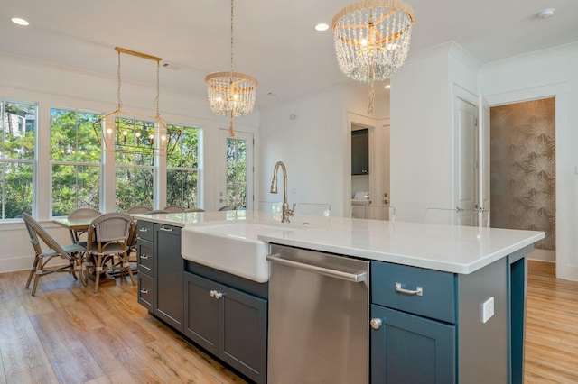 kitchen featuring a center island with sink, sink, hanging light fixtures, stainless steel dishwasher, and a notable chandelier