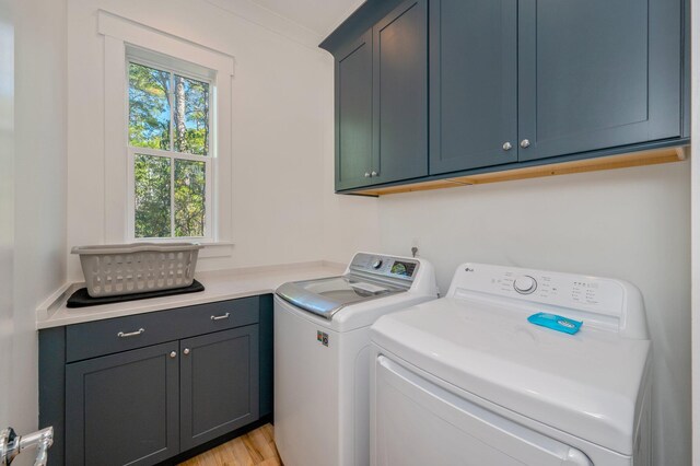 washroom featuring light hardwood / wood-style floors, cabinets, crown molding, and washing machine and dryer